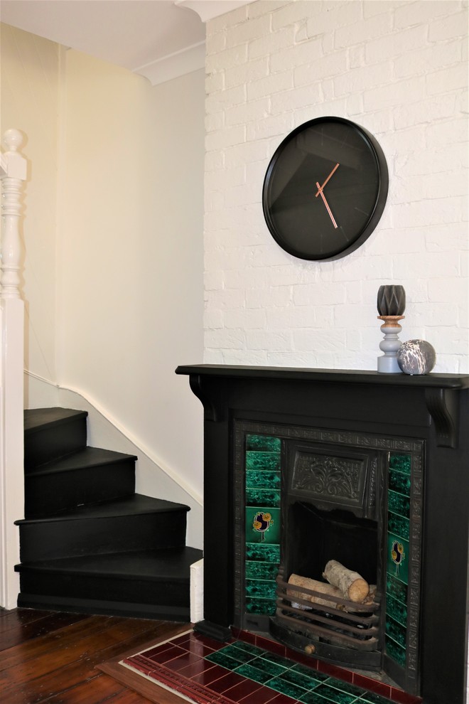 ニューカッスルにあるお手頃価格の小さなヴィクトリアン調のおしゃれなLDK (グレーの壁、淡色無垢フローリング、標準型暖炉、木材の暖炉まわり) の写真