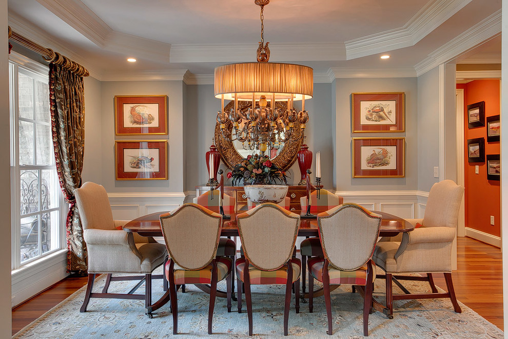 This is an example of a medium sized traditional dining room in Raleigh with blue walls and medium hardwood flooring.