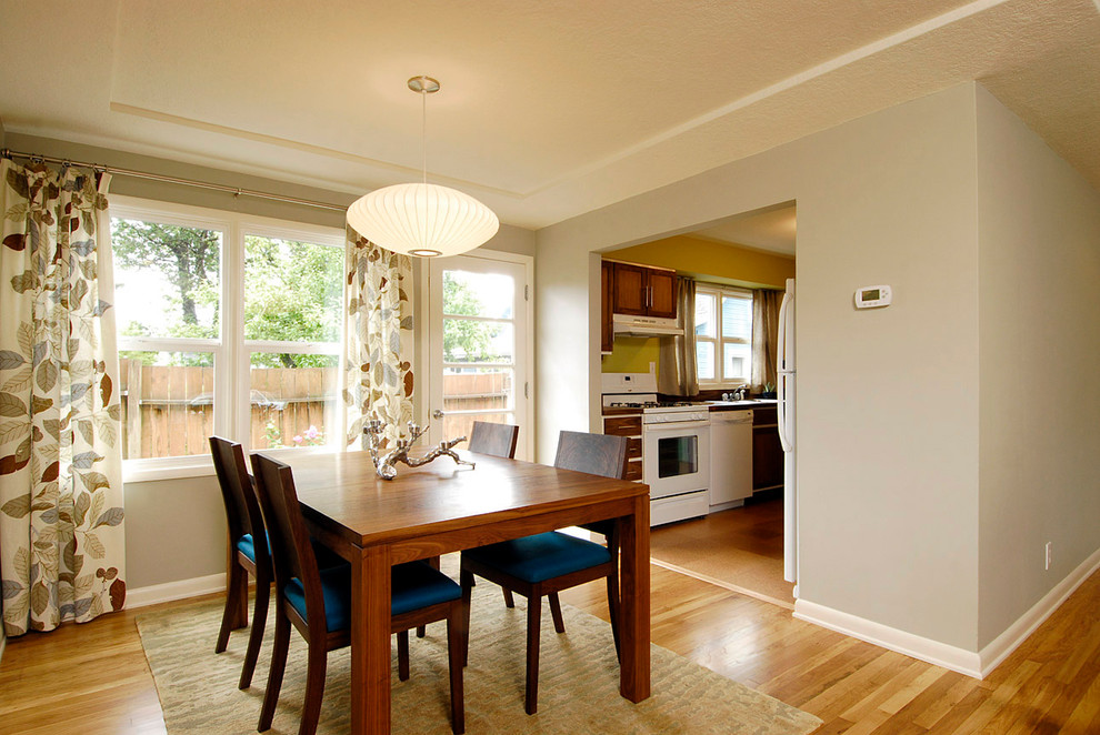 Aménagement d'une salle à manger moderne avec un mur beige et un sol en bois brun.