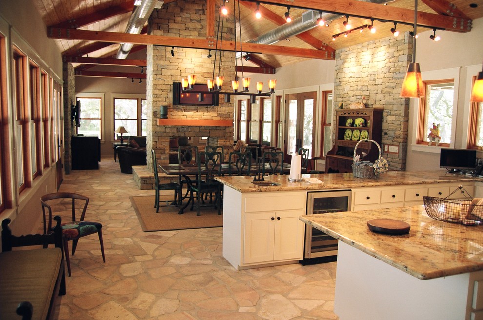 На фото: маленькая кухня-столовая в стиле кантри с бежевыми стенами, двусторонним камином и фасадом камина из камня для на участке и в саду с