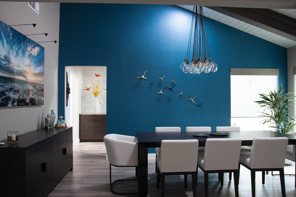 На фото: большая отдельная столовая в современном стиле с синими стенами, полом из керамогранита, серым полом, балками на потолке и обоями на стенах без камина с