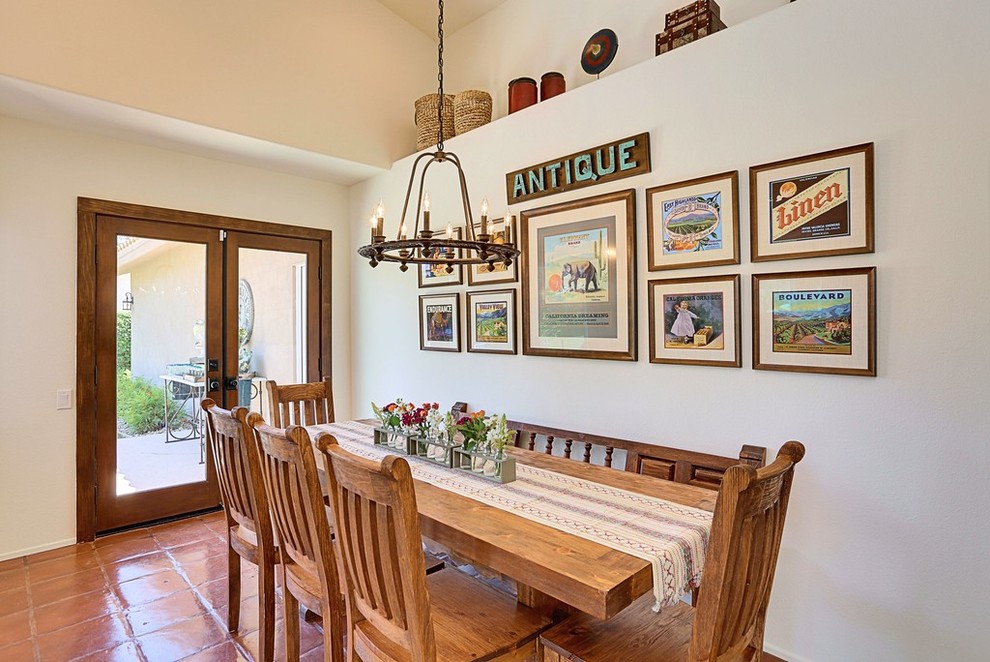 Cette photo montre une salle à manger sud-ouest américain avec un mur beige et tomettes au sol.
