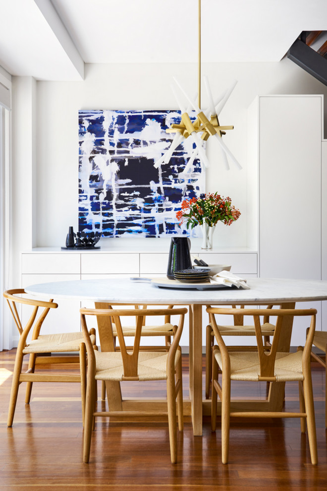 Inspiration pour une petite salle à manger design avec un mur blanc, un sol marron et un sol en bois brun.
