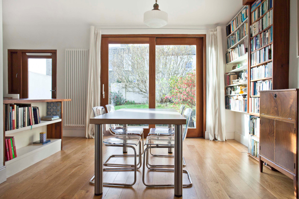 Réalisation d'une petite salle à manger ouverte sur la cuisine design avec un mur blanc et un sol en bois brun.