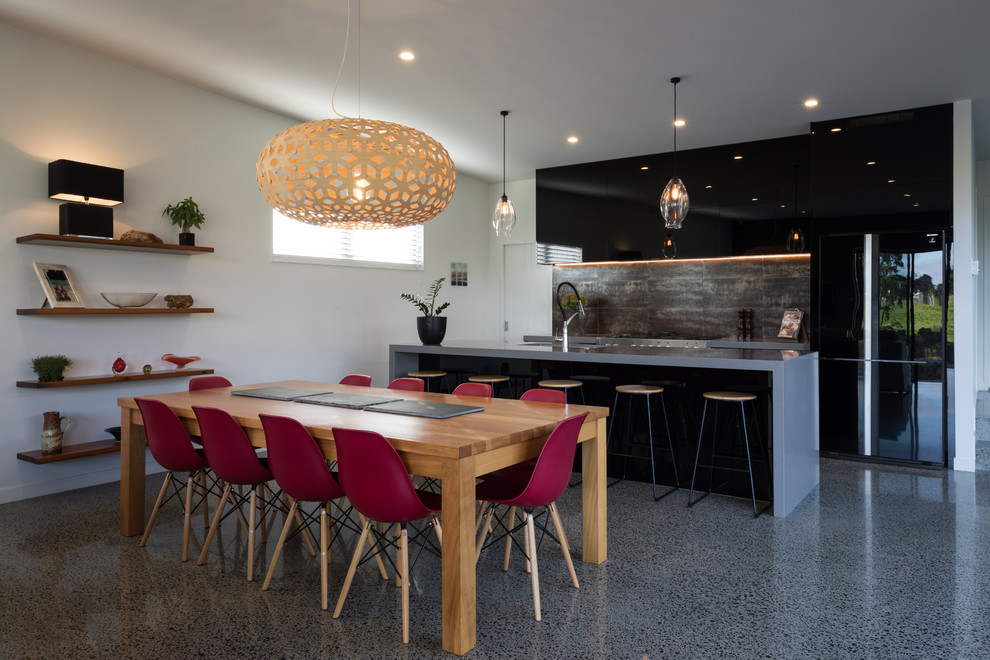 Exemple d'une salle à manger ouverte sur le salon tendance de taille moyenne avec sol en béton ciré, un mur blanc et un sol gris.