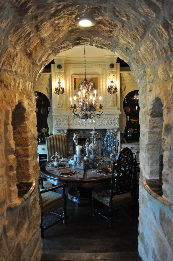 Immagine di una sala da pranzo mediterranea chiusa e di medie dimensioni con parquet scuro, camino classico e cornice del camino in pietra