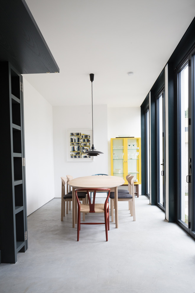 Photo of a medium sized scandi dining room in Dublin with white walls, concrete flooring and grey floors.