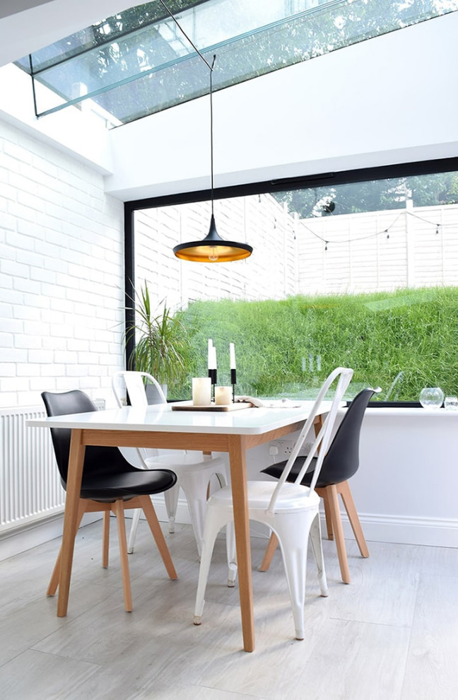 Inspiration for a scandi dining room in London with white walls, grey floors, a vaulted ceiling and brick walls.
