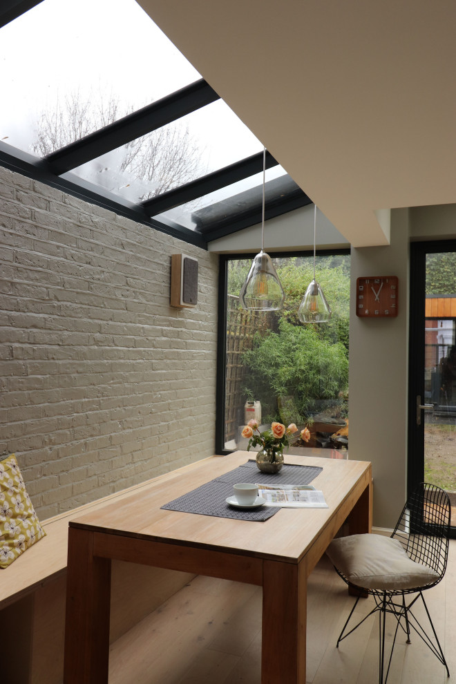Inspiration pour une salle à manger ouverte sur la cuisine nordique de taille moyenne avec un mur gris et parquet clair.