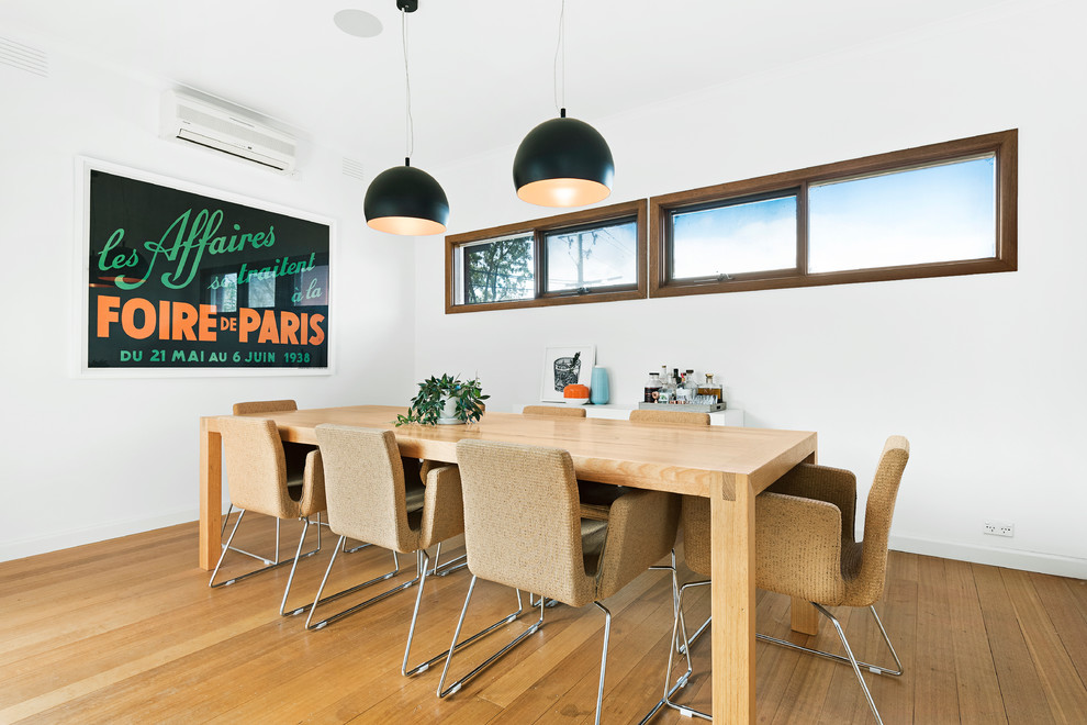 Geschlossenes, Mittelgroßes Modernes Esszimmer ohne Kamin mit weißer Wandfarbe, braunem Holzboden und braunem Boden in Melbourne