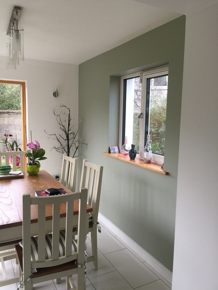 Esempio di una piccola sala da pranzo aperta verso la cucina contemporanea con pareti verdi, pavimento in gres porcellanato e pavimento bianco
