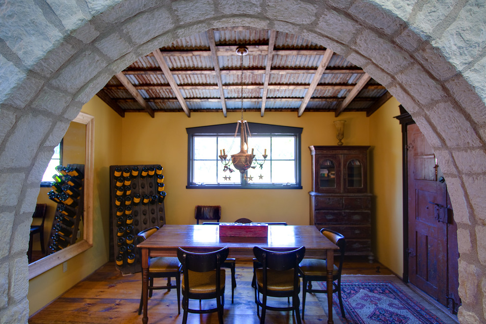 Idée de décoration pour une salle à manger chalet de taille moyenne avec un mur jaune et un sol en bois brun.