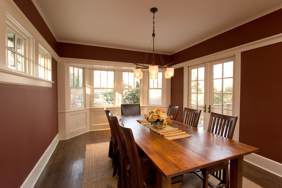 Idées déco pour une grande salle à manger craftsman fermée avec un mur rouge, un sol en bois brun et aucune cheminée.