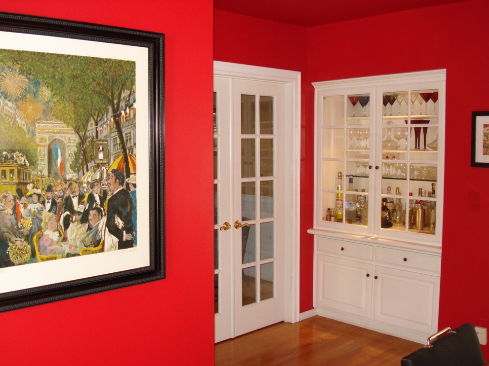 Photo of a medium sized eclectic enclosed dining room in Los Angeles with red walls and light hardwood flooring.