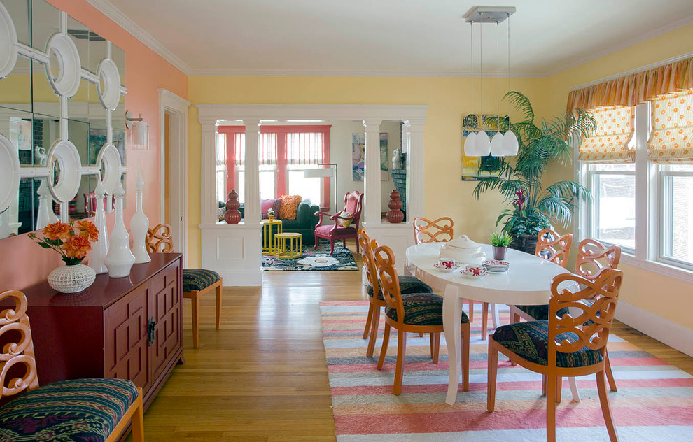 Large bohemian kitchen/dining room in Boston with multi-coloured walls, light hardwood flooring and feature lighting.