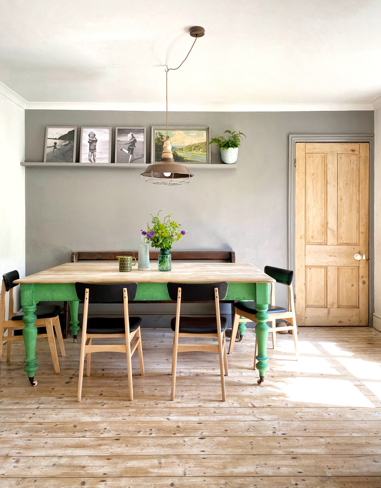 Exemple d'une salle à manger ouverte sur la cuisine éclectique avec un mur gris, un sol en bois brun, aucune cheminée et un sol marron.