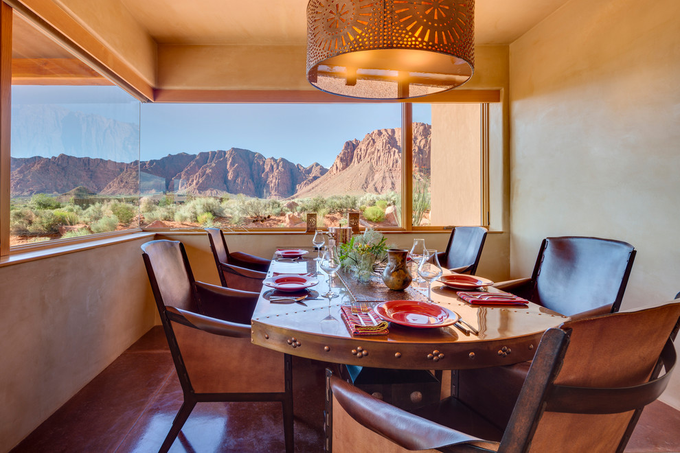 Cette photo montre une salle à manger sud-ouest américain avec un mur beige et un sol marron.