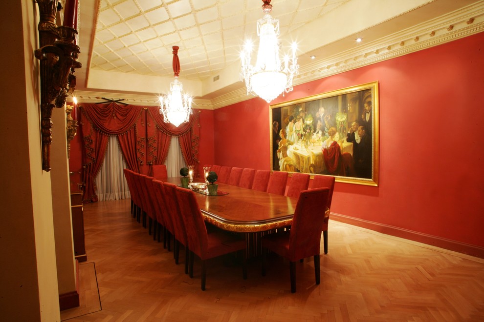 Foto de comedor tradicional con paredes rojas, suelo de madera en tonos medios y cortinas