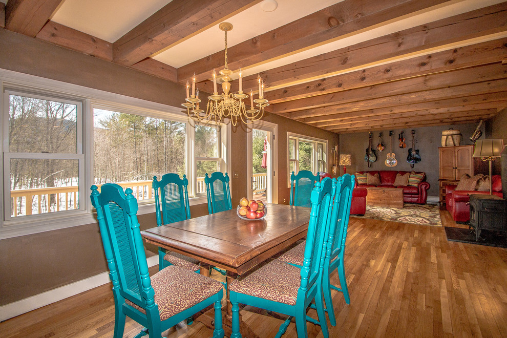 Mittelgroße Country Wohnküche mit brauner Wandfarbe, braunem Holzboden, Kaminofen, Kaminumrandung aus Backstein und braunem Boden in Portland Maine