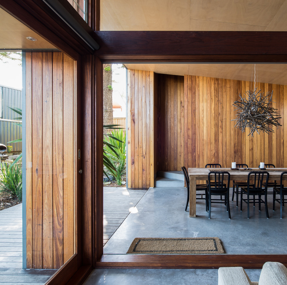 Ispirazione per una sala da pranzo minimal con pareti marroni e pavimento in cemento