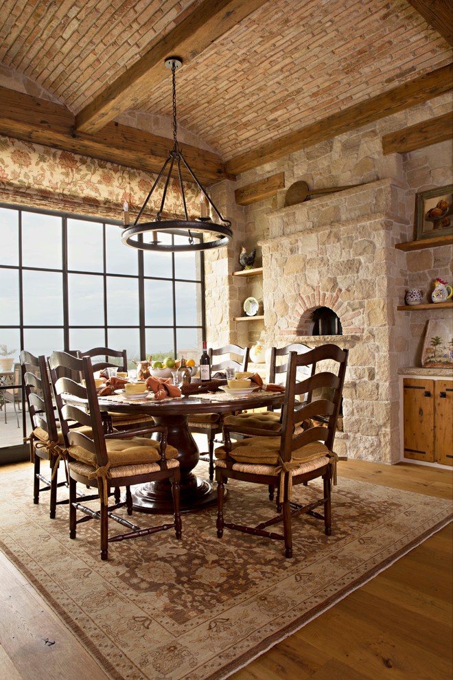 Cette image montre une salle à manger méditerranéenne avec un sol en bois brun.