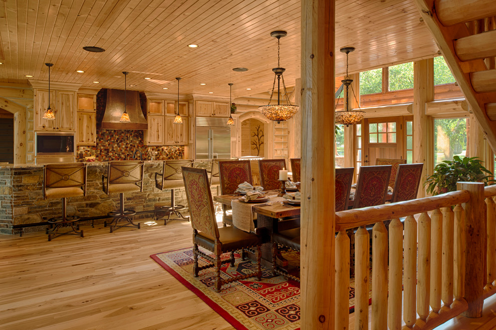 Réalisation d'une salle à manger ouverte sur la cuisine chalet avec un sol en bois brun.