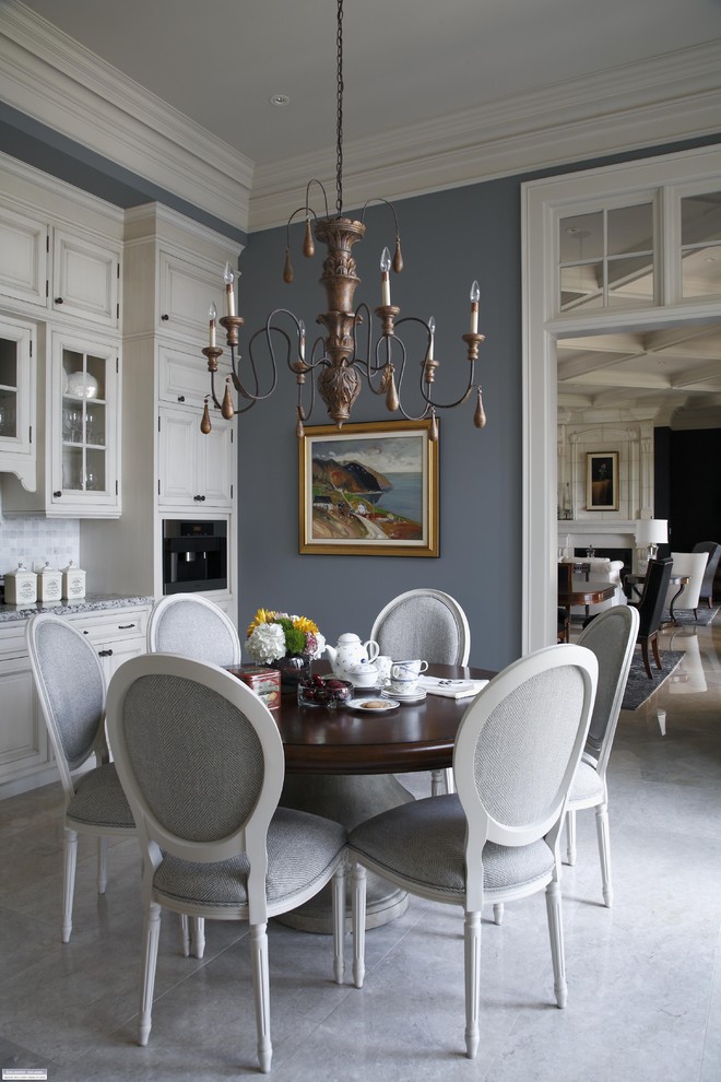 Cette image montre une salle à manger ouverte sur la cuisine traditionnelle avec un mur gris.