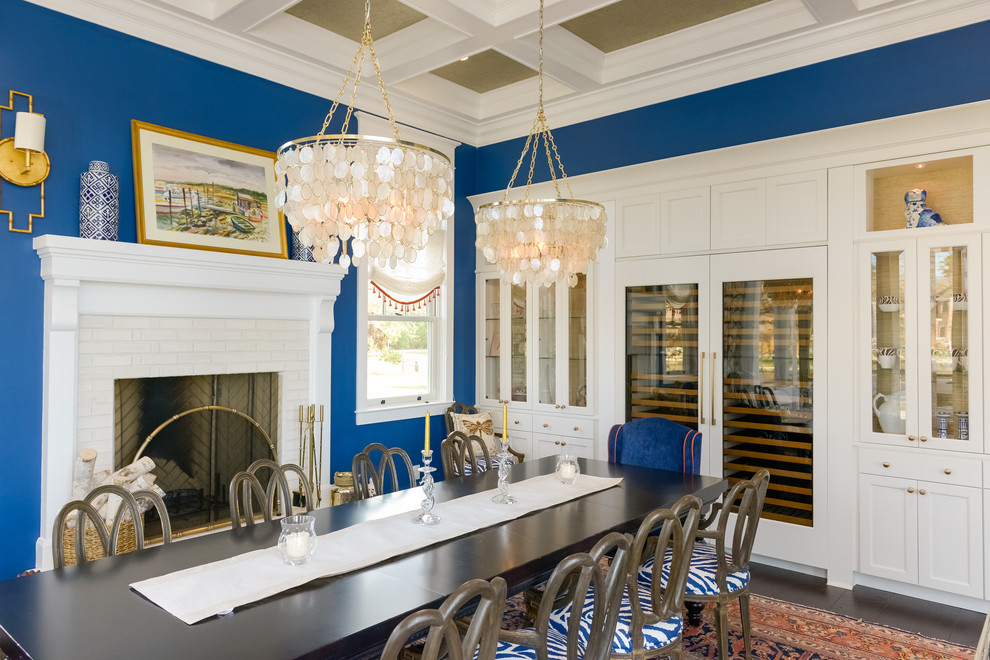 На фото: отдельная столовая в морском стиле с синими стенами, темным паркетным полом, стандартным камином и коричневым полом