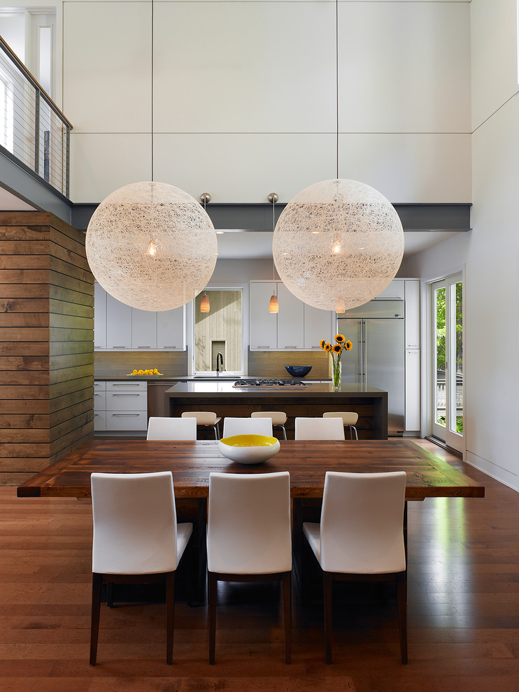Стильный дизайн: огромная кухня-столовая в современном стиле с белыми стенами и паркетным полом среднего тона - последний тренд