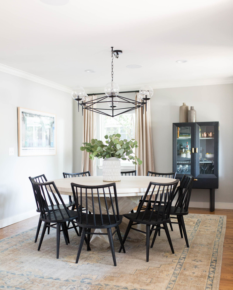 Example of a transitional medium tone wood floor and brown floor dining room design in Sacramento with gray walls