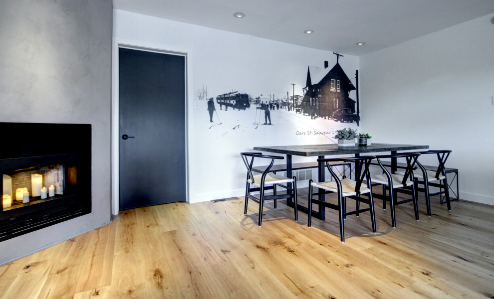 Example of a mid-sized medium tone wood floor and wallpaper breakfast nook design in Montreal with white walls, a corner fireplace and a concrete fireplace