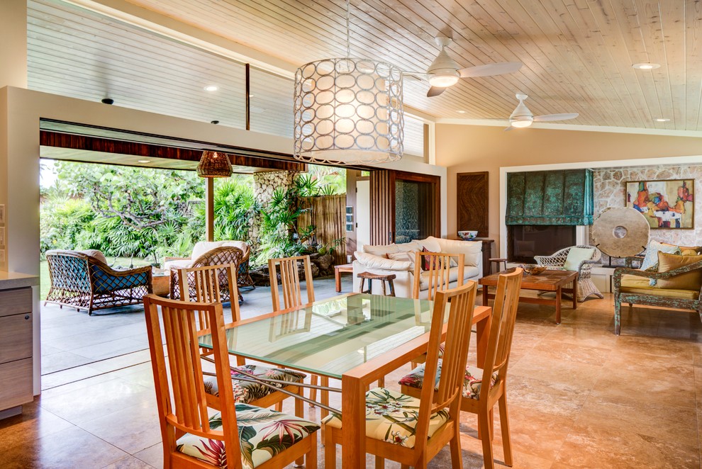 Immagine di una sala da pranzo aperta verso il soggiorno tropicale con pareti beige