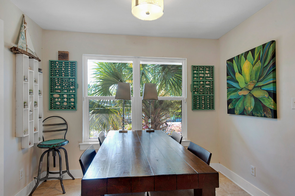 Aménagement d'une salle à manger exotique fermée et de taille moyenne avec un mur beige, un sol en carrelage de céramique, aucune cheminée et un sol beige.