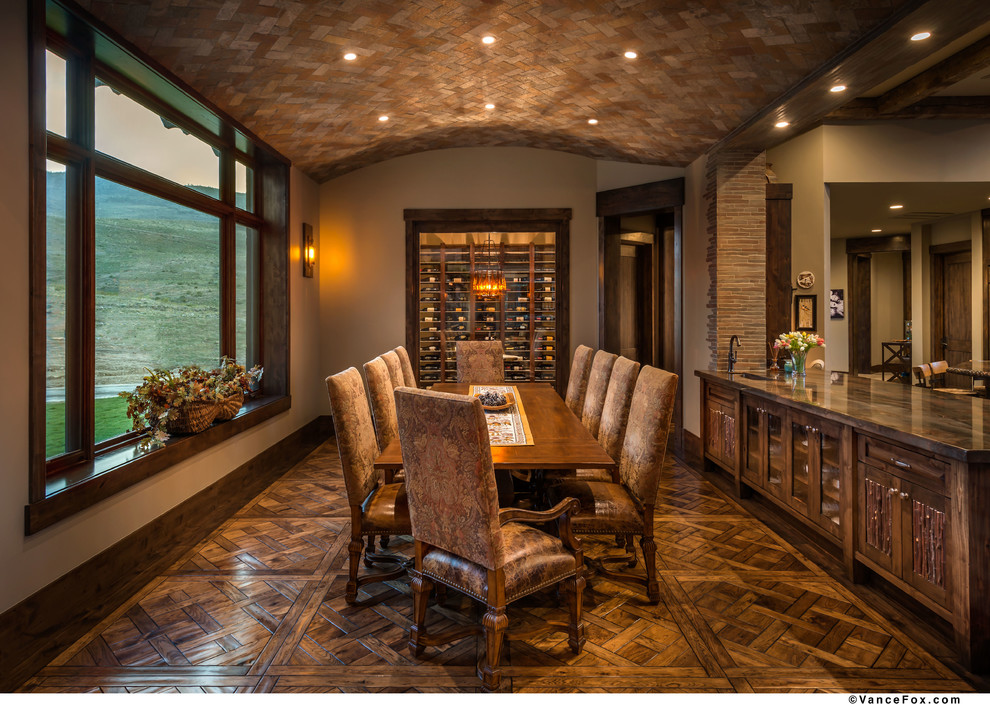 Foto di una grande sala da pranzo aperta verso la cucina rustica con pareti beige, pavimento in legno massello medio e nessun camino