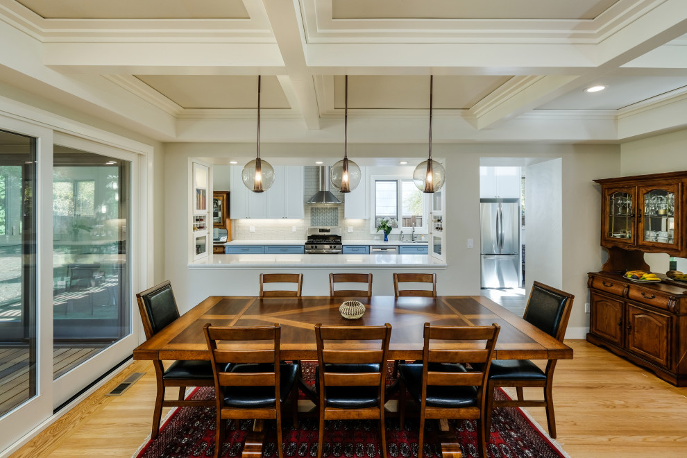 Immagine di una sala da pranzo classica di medie dimensioni con pareti beige, parquet chiaro, pavimento marrone e soffitto a cassettoni
