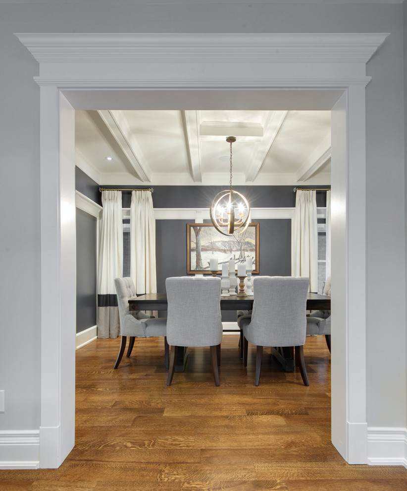 Example of a mid-sized transitional medium tone wood floor enclosed dining room design in Toronto with blue walls and no fireplace