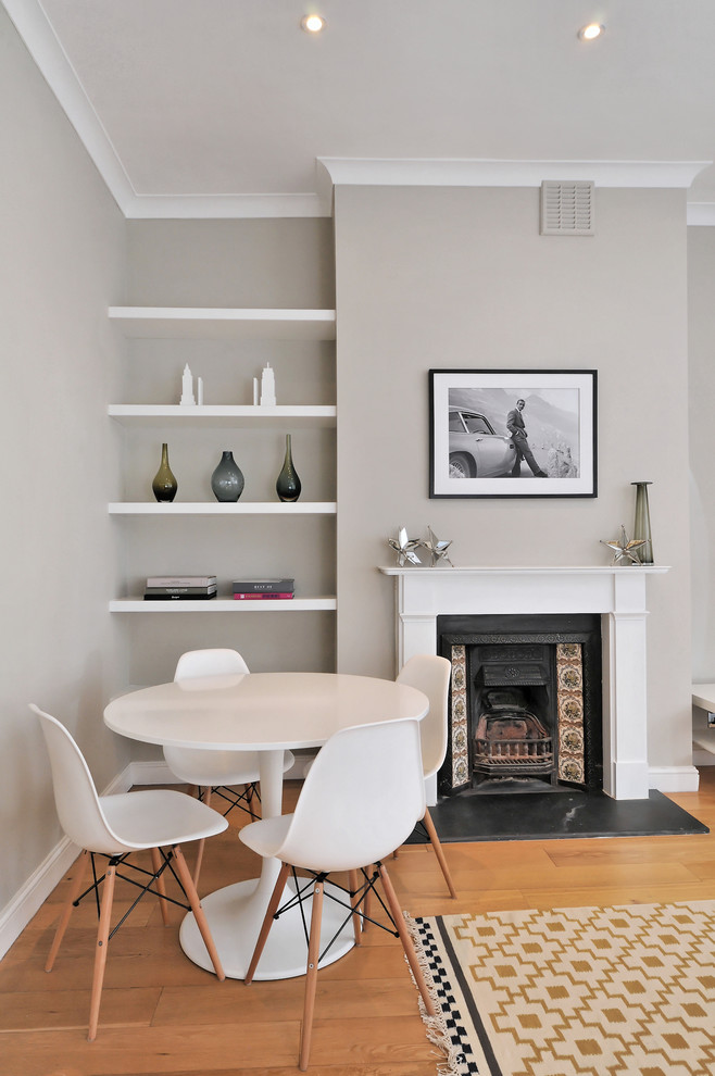Источник вдохновения для домашнего уюта: столовая в современном стиле с серыми стенами и стандартным камином