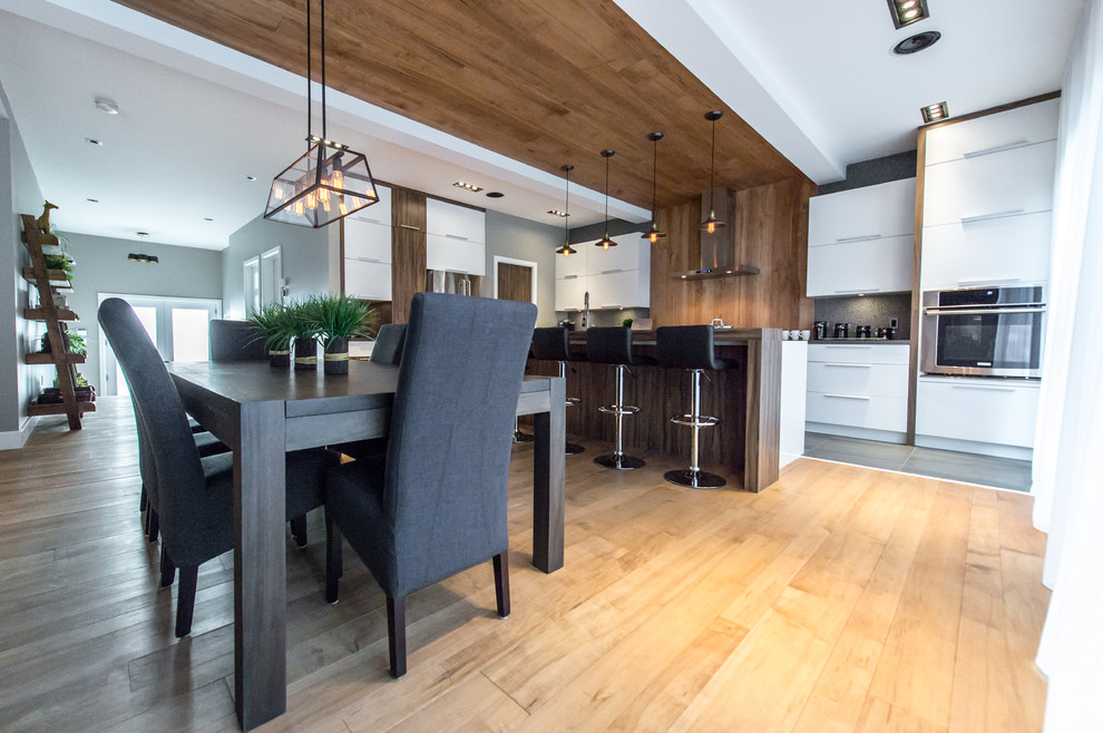 Example of a trendy kitchen/dining room combo design in Montreal with a two-sided fireplace