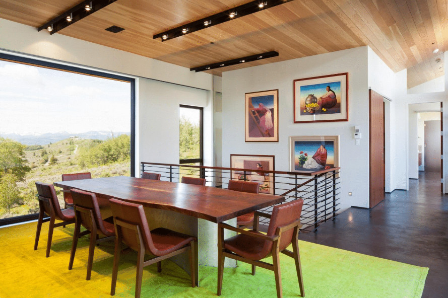 Immagine di una sala da pranzo aperta verso il soggiorno contemporanea di medie dimensioni con pareti bianche, pavimento in cemento e pavimento marrone