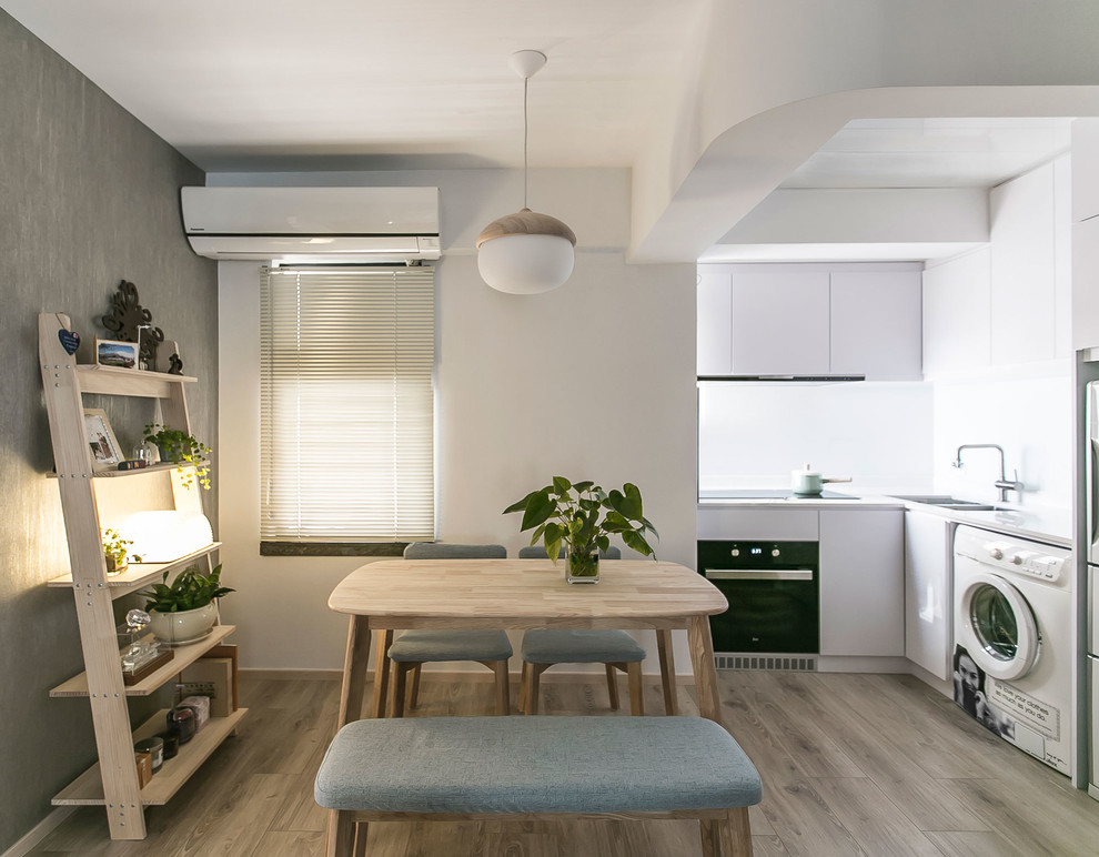 Foto di una piccola sala da pranzo aperta verso la cucina design con pareti multicolore, pavimento in laminato e pavimento beige