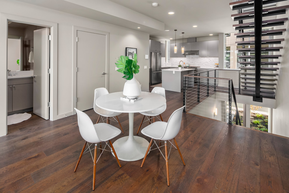 Design ideas for a contemporary dining room in Seattle with white walls, dark hardwood flooring and brown floors.