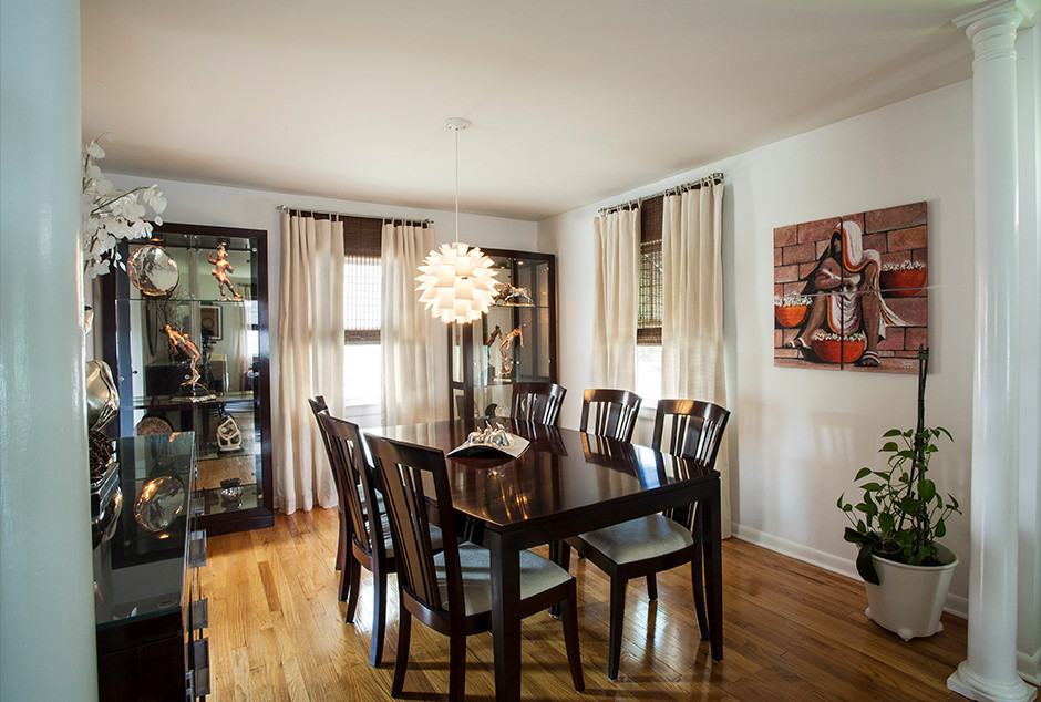 Example of a mid-sized trendy light wood floor enclosed dining room design in New York with white walls