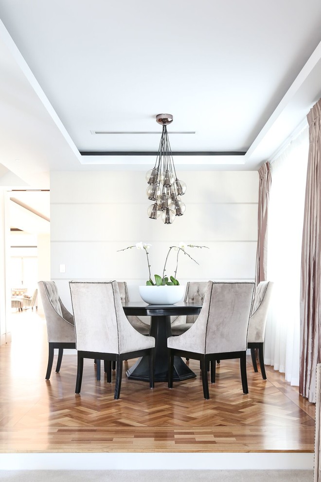 This is an example of a traditional dining room in Melbourne with light hardwood flooring.