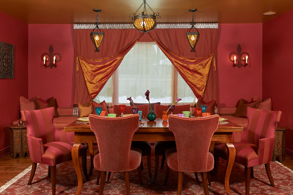 Aménagement d'une salle à manger éclectique fermée avec un mur rouge, parquet foncé et un sol marron.