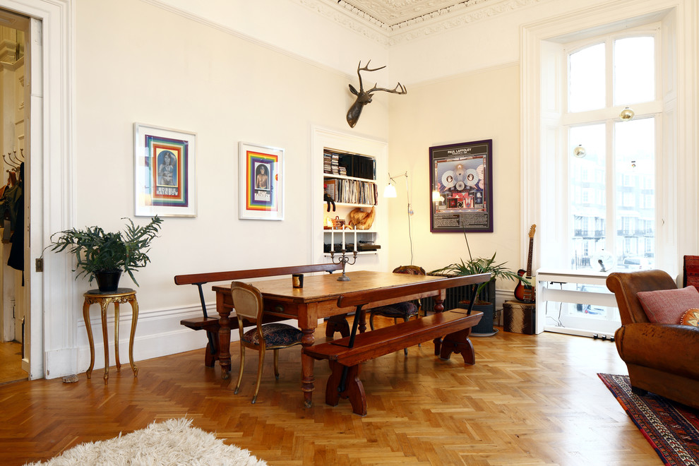 Modelo de comedor nórdico grande abierto con paredes beige y suelo de madera en tonos medios