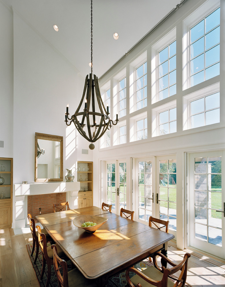 Design ideas for a traditional dining room in New York with white walls, medium hardwood flooring and a standard fireplace.