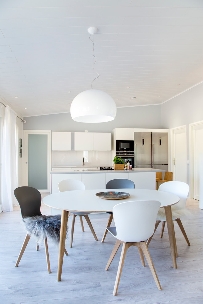 Immagine di una sala da pranzo aperta verso la cucina scandinava di medie dimensioni con pareti grigie e parquet chiaro