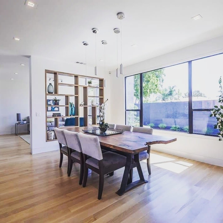 Example of a mid-sized minimalist medium tone wood floor and brown floor great room design in Sacramento with white walls and no fireplace