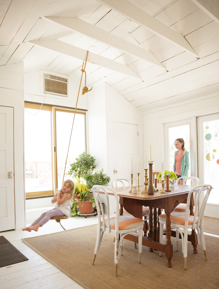 Immagine di una sala da pranzo country con pareti bianche e pavimento in legno verniciato