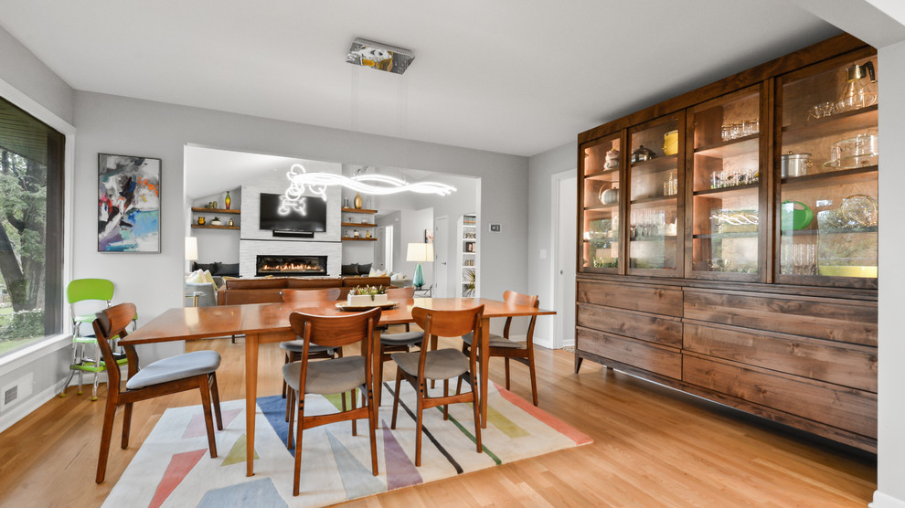 Foto di una piccola sala da pranzo minimalista chiusa con pareti bianche e pavimento in legno massello medio